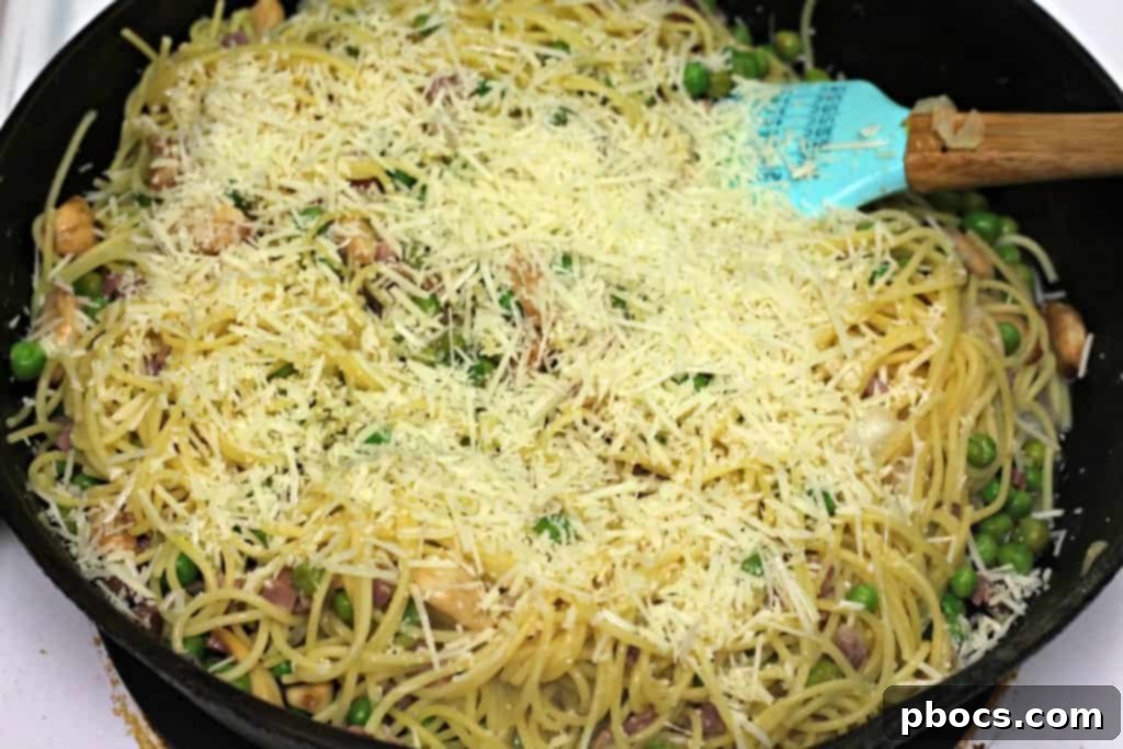 Quick Pancetta and Sweet Pea Pasta 11 Adding grated Parmesan cheese to the finished Easy Pancetta Pea Pasta