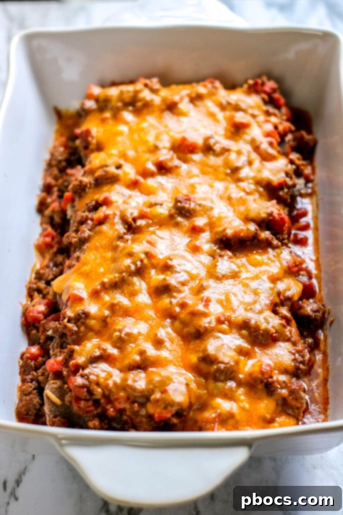 Low Carb Chili Cheese Dog Bake topped with cheese, ready for baking.