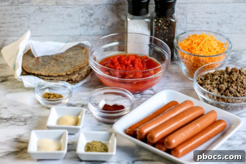 Close-up of the assembled Low Carb Chili Cheese Dog Bake before baking, showing chili and hot dogs.