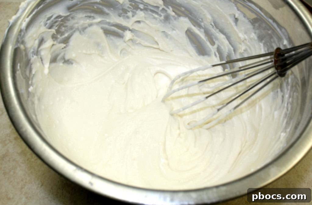 Using parchment paper to press keto cheesecake crust.