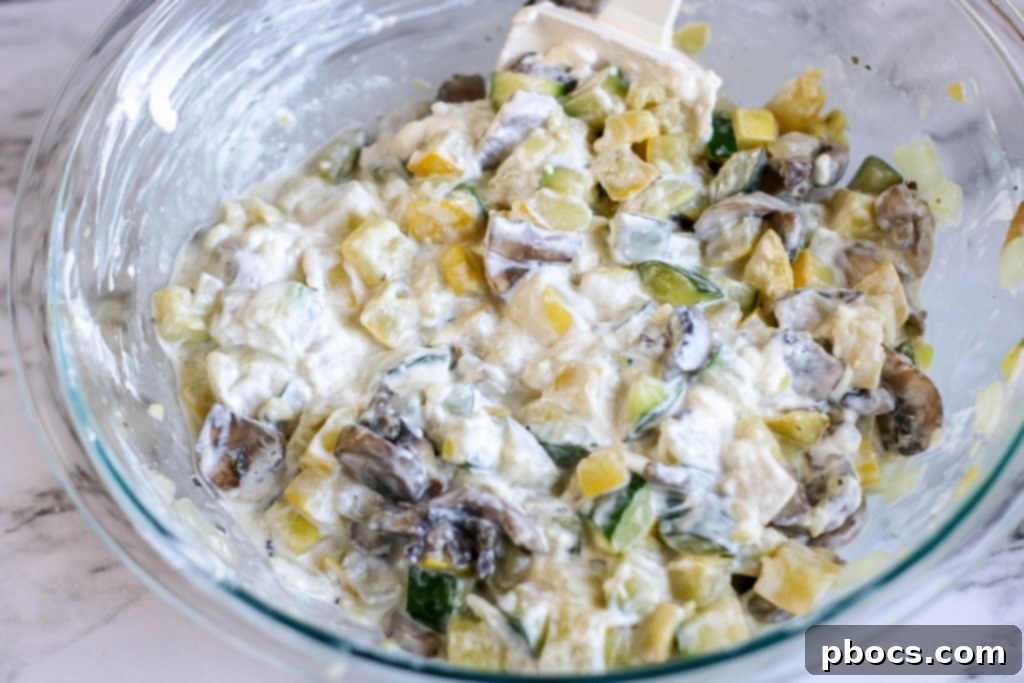 Mixing cream cheese, sour cream, and garlic powder for casserole