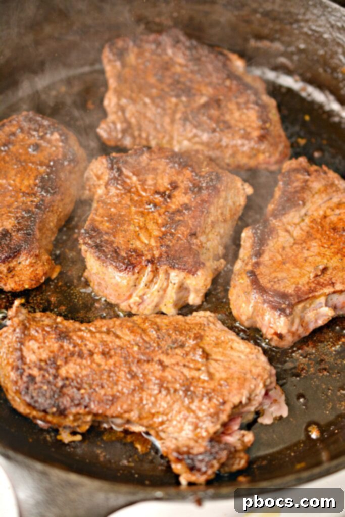 Sizzling Keto Steak Fajita Lettuce Wraps 9 Sizzling sirloin steak cooking in a hot skillet for fajitas.