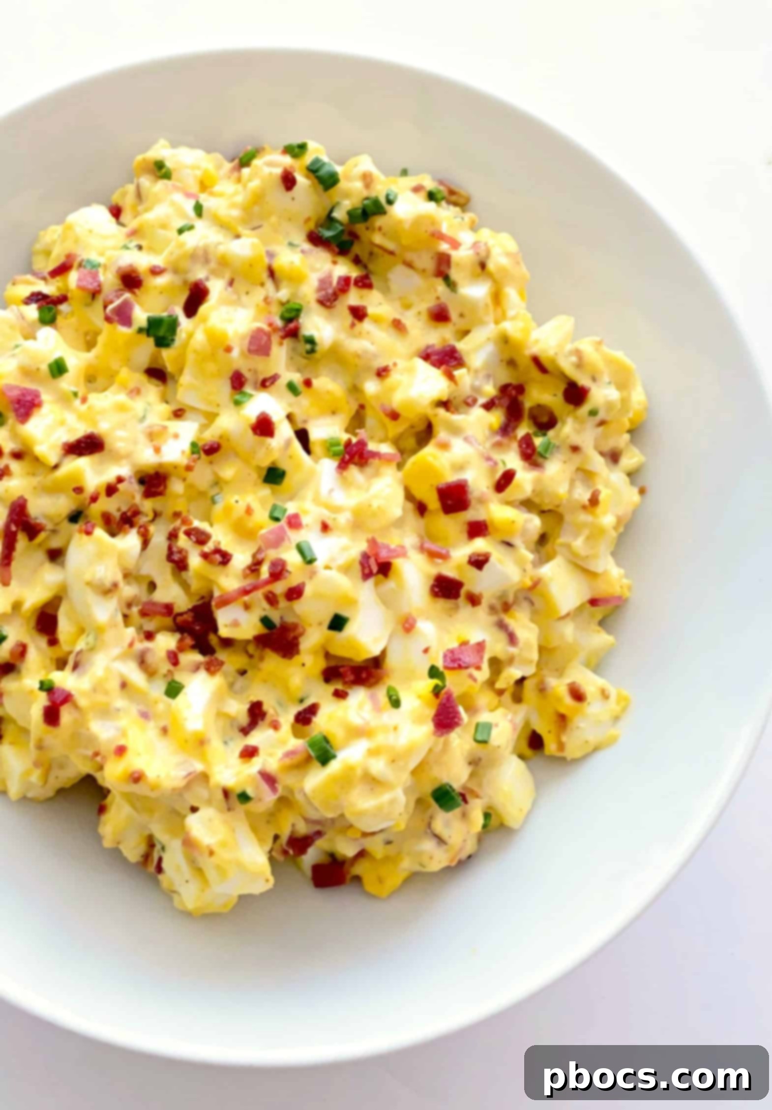 Keto Deviled Egg Salad served in a bowl with various low-carb accompaniments like lettuce cups, celery sticks, and avocado.