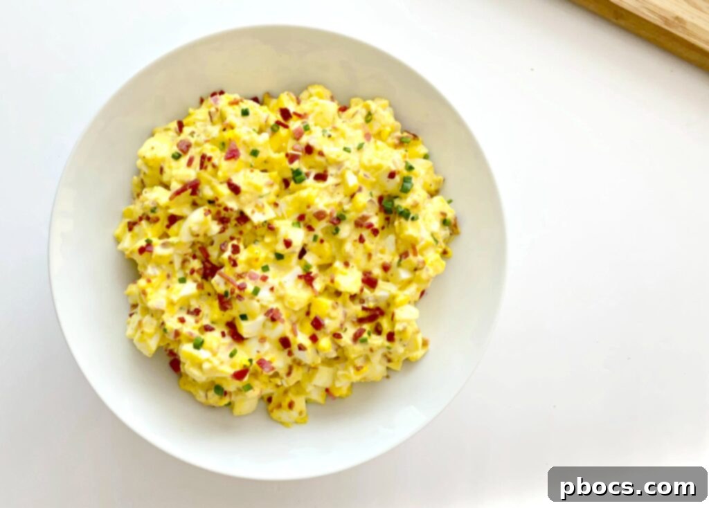 Keto Deviled Eggs Salad being stirred in a large bowl, showing its creamy consistency.