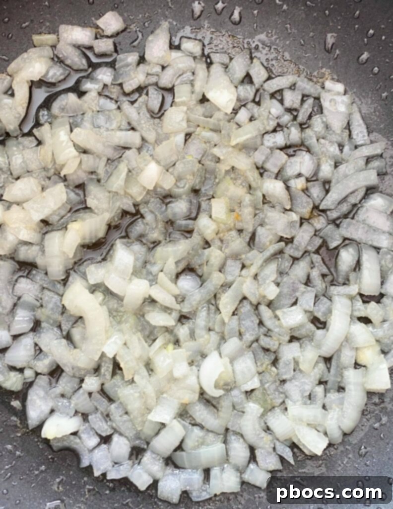 Diced onions and garlic cooking in a skillet