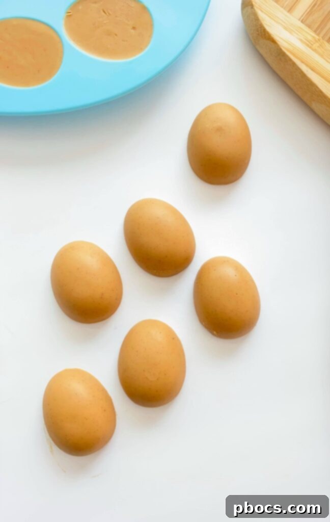 Guilt-Free Keto Chocolate Easter Eggs 6 Spoon peanut butter mixture into silicone molds for Keto Chocolate Easter Eggs.