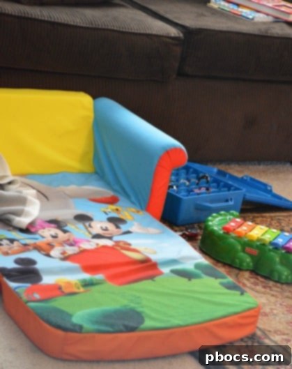 A close-up view of a child's hand reaching for toys on the floor amidst a cozy living room setting, illustrating active play.