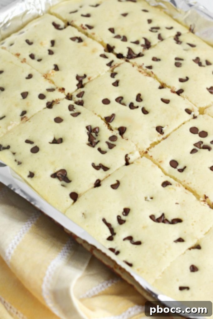 Freshly baked Keto Sheet Pan Pancakes, golden brown and fluffy, sliced into perfect squares on a cutting board, ready for serving.