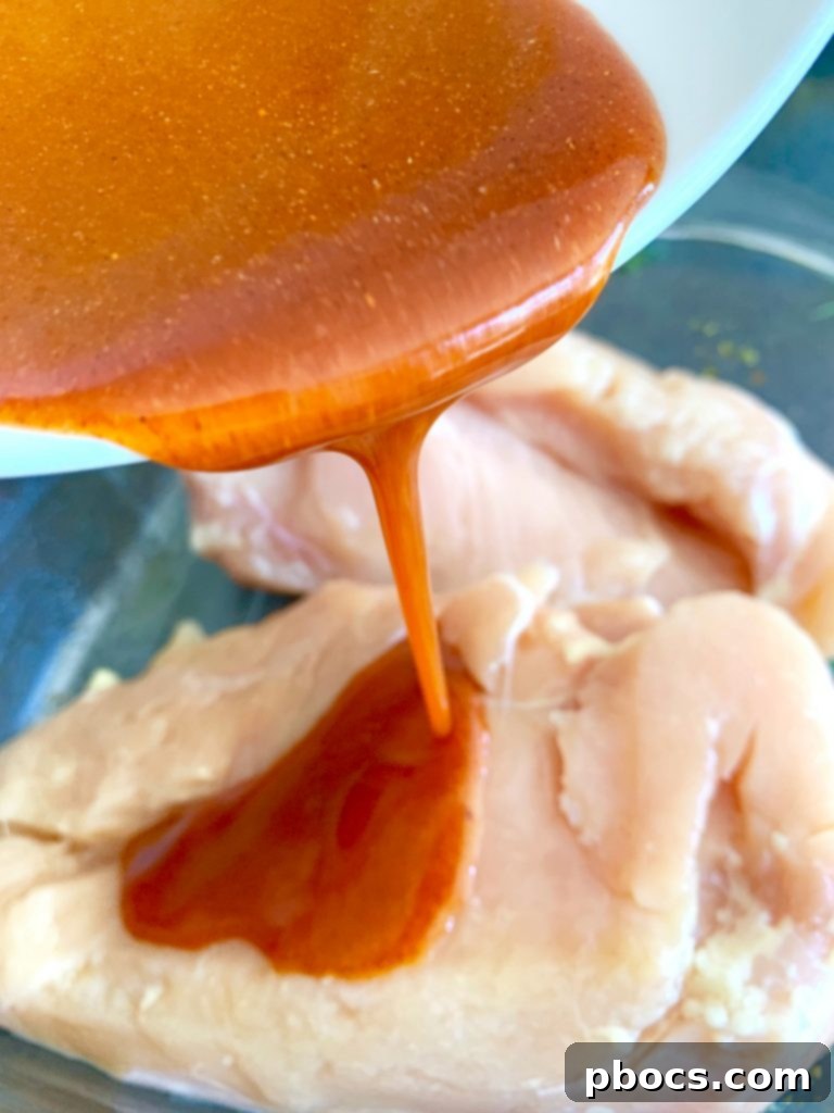 Chicken breasts marinating in a Ziploc bag with buffalo sauce.