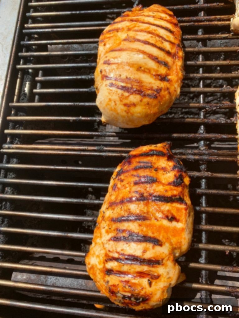Grilled buffalo chicken on a platter, ready to be sliced.