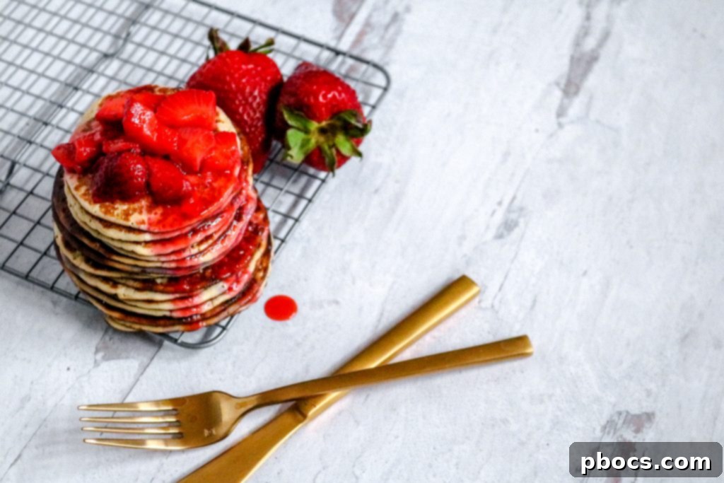 Plated Keto Strawberry Pancakes with sauce and fresh berries