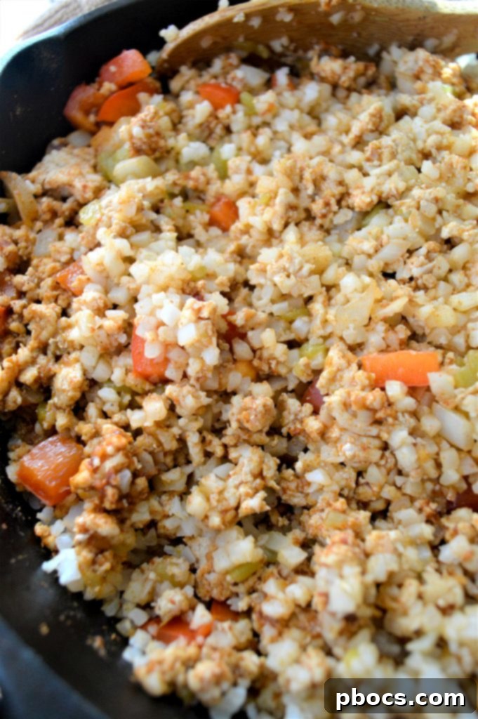 Diced onions, bell peppers, and taco seasoning mixed with browned ground turkey in a skillet, cooking to perfection.
