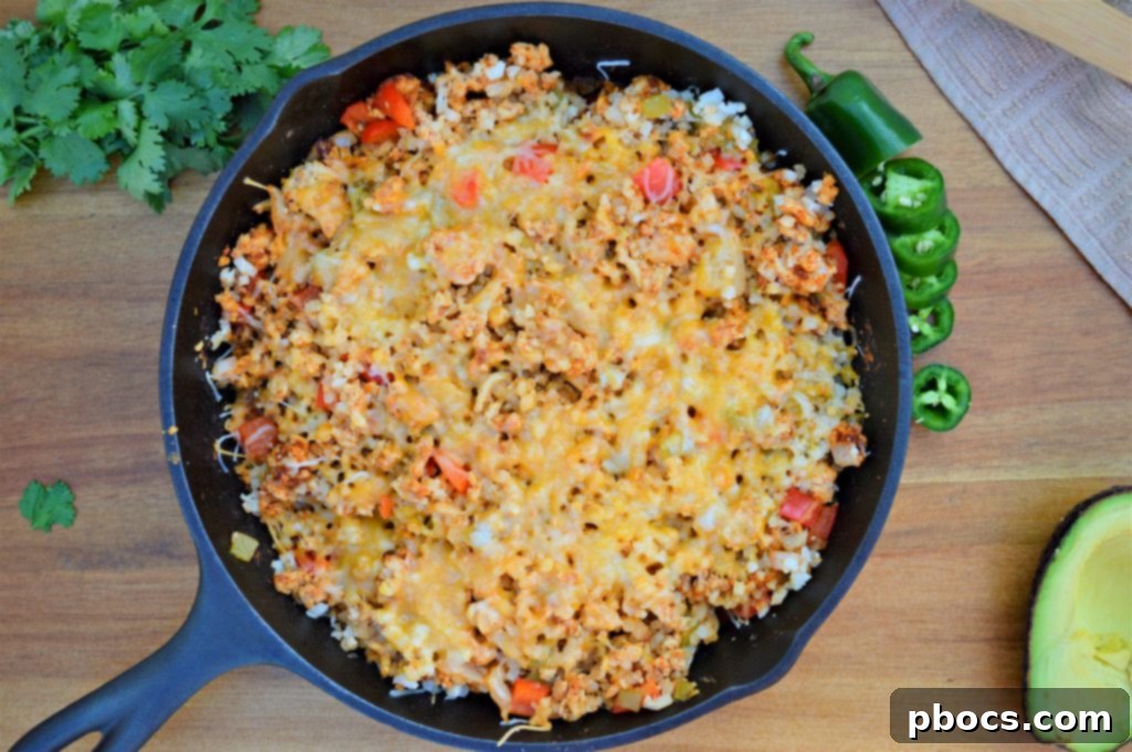 Green chiles and cauliflower rice stirred into the turkey and vegetable mixture in the skillet, simmering.