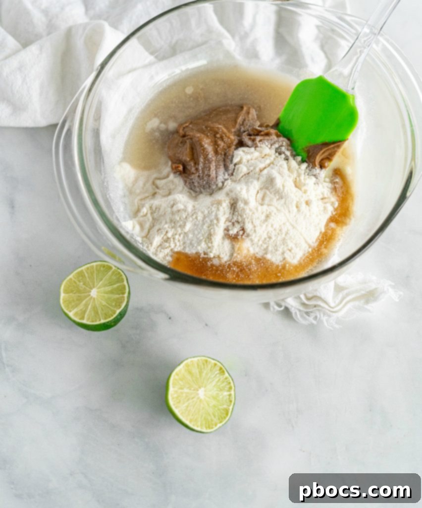 Refreshing Keto Key Lime Fat Bombs 9 Hands expertly mixing all the ingredients for Keto Key Lime Fat Bombs together in a bowl.