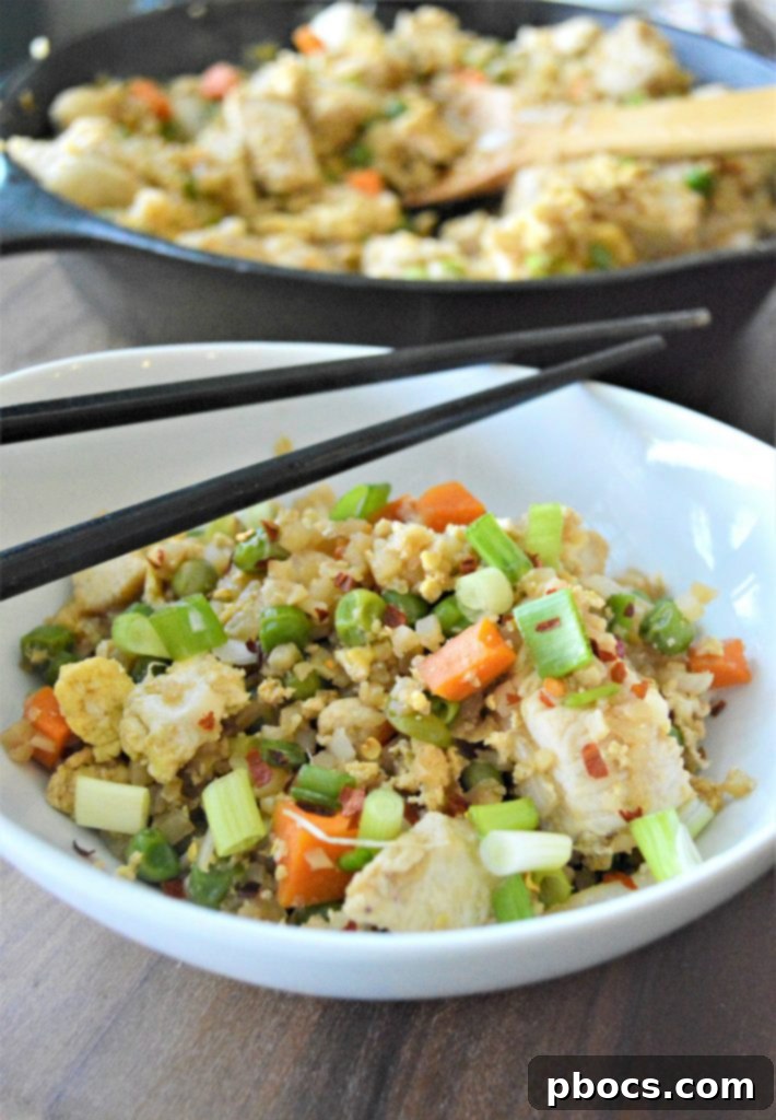 Close-up of Keto Cauliflower Chicken Fried Rice in a skillet, showcasing ingredients