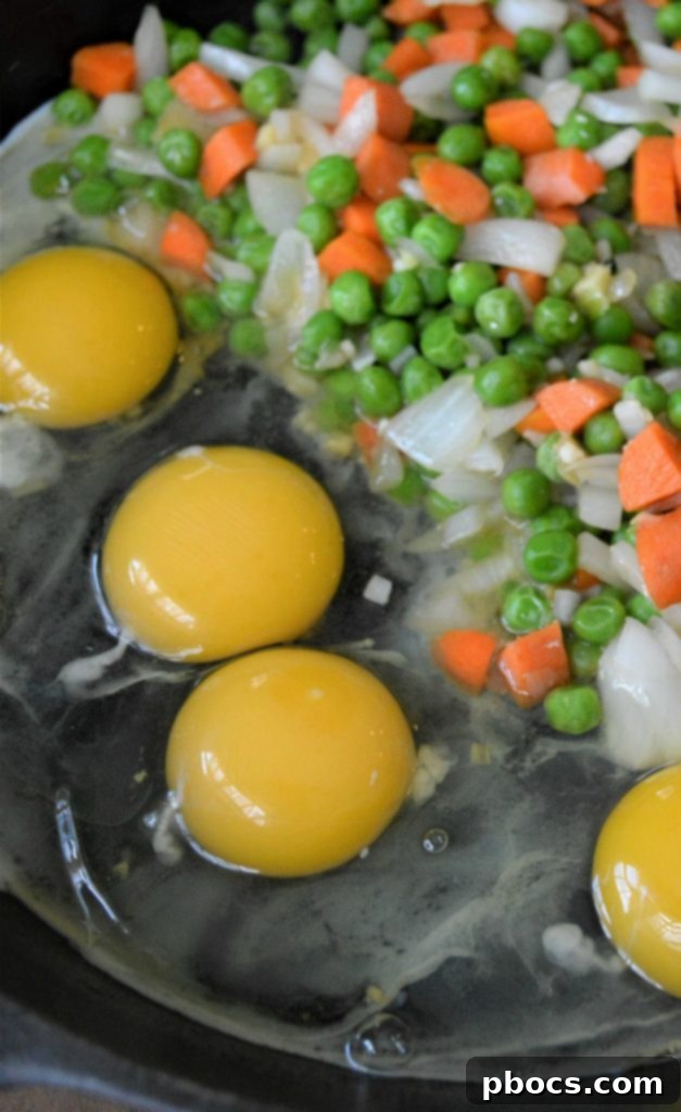 Sautéing vegetables (onion, garlic, carrots, peas, ginger) in a skillet