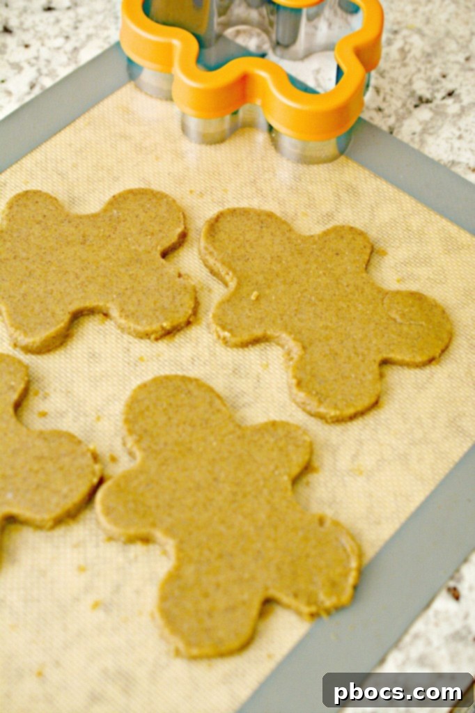 Festive Keto Gingerbread Snaps 10 Rolling out Keto Gingerbread Cookie dough between parchment paper