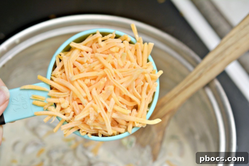Spicy Keto Jalapeno Popper Green Bean Casserole 10 Step-by-step photo of creamy sauce being whisked with cream cheese, jalapeno, and heavy cream