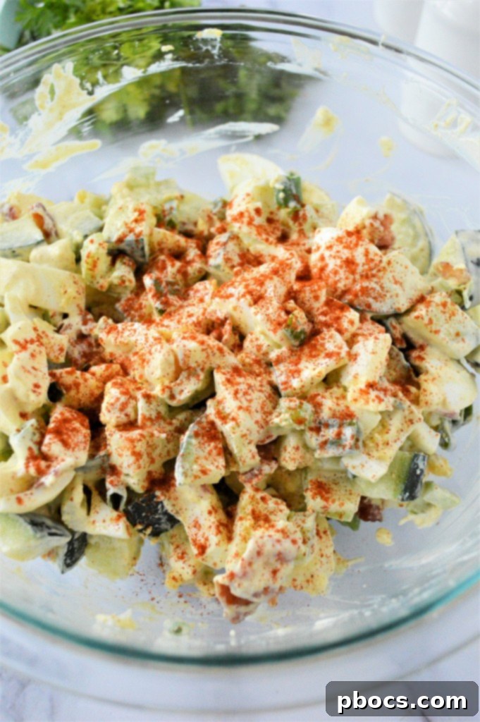 Step 5: Mixing in fresh parsley and paprika into the egg salad.