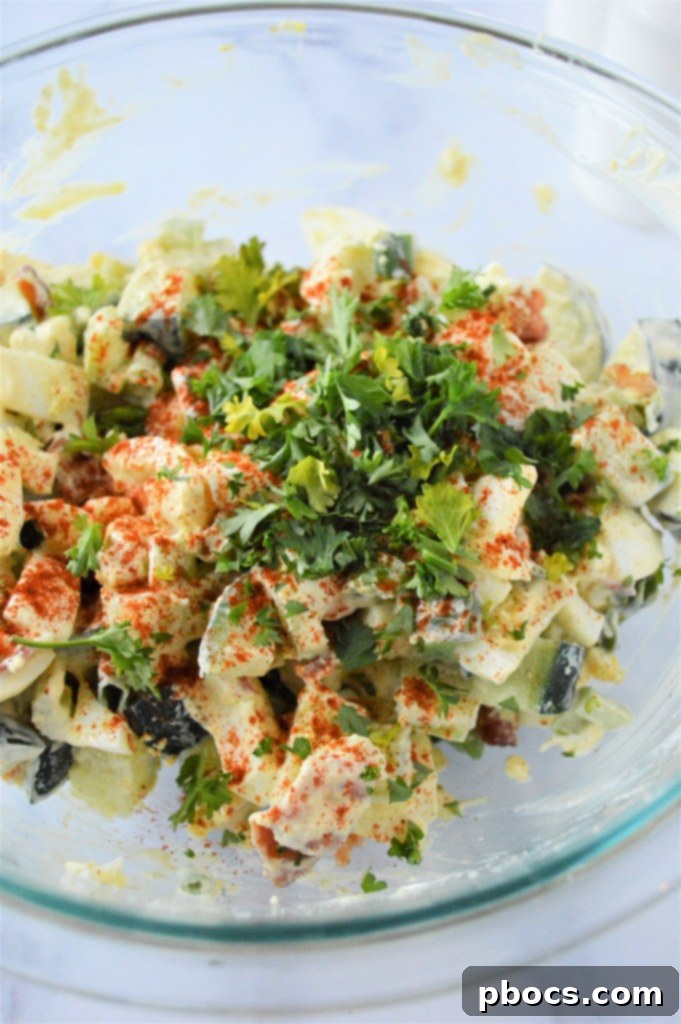 Step 6: Garnishing the Low Carb Cucumber Egg Salad with extra bacon and parsley.