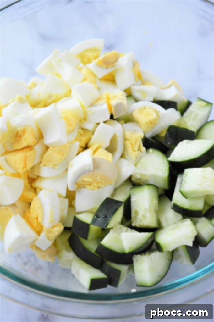 Step 1: Combining chopped eggs and cucumber for the salad.