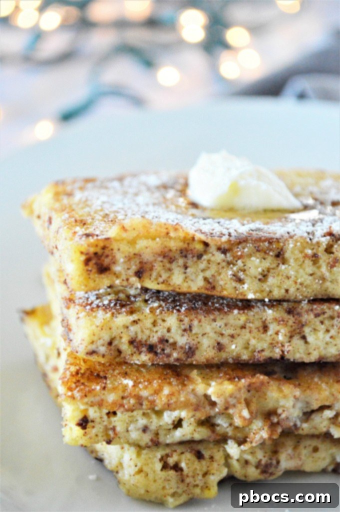 Rich Eggnog Keto French Toast garnished with powdered sugar substitute and berries