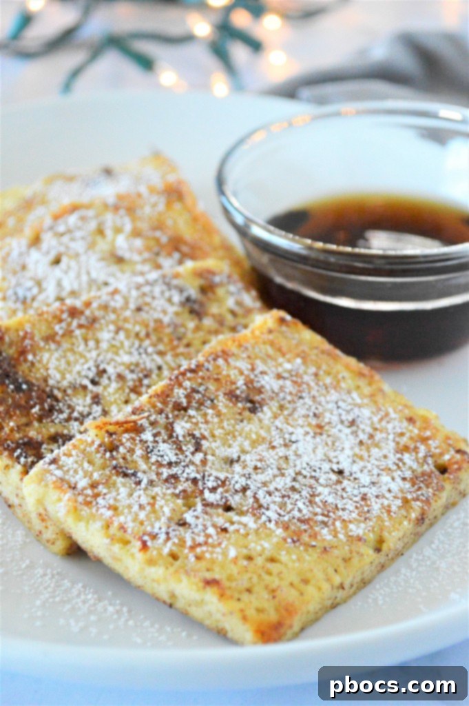 A stack of Eggnog Keto French Toast with a dusting of powdered sugar substitute