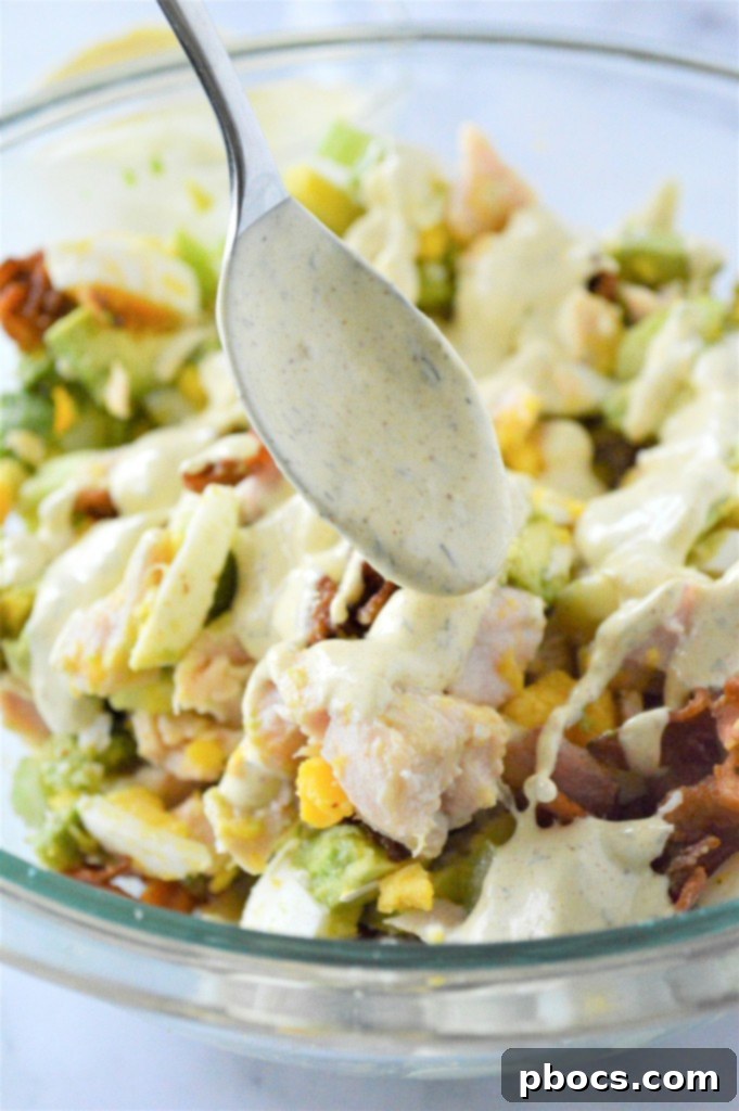 Step 3: Spooning the dressing over the chicken mixture and tossing well