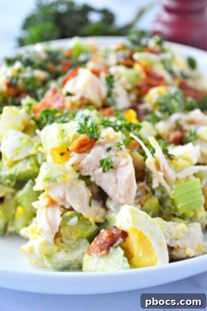 A close up shot of a vibrant Low Carb Chicken Egg Salad in a bowl, showing the texture of the ingredients