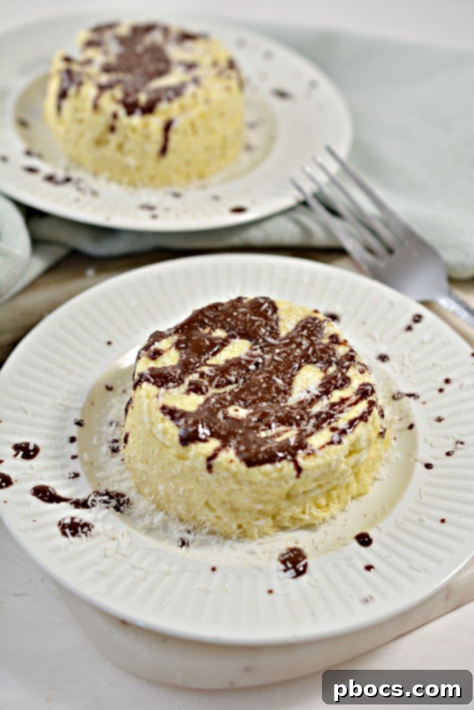 Effortless Keto Mug Cheesecake 2 Delicious Easy Keto Mug Cheesecake served in a mug with chocolate drizzle and coconut flakes