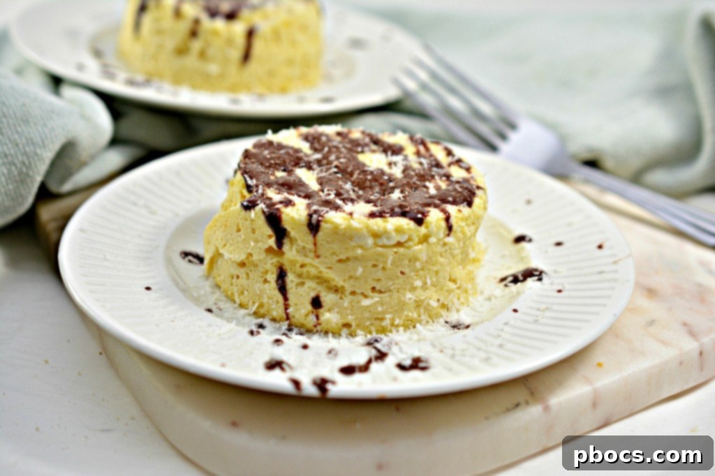 Effortless Keto Mug Cheesecake 7 Two keto mug cheesecakes ready to be served, topped with chocolate and coconut