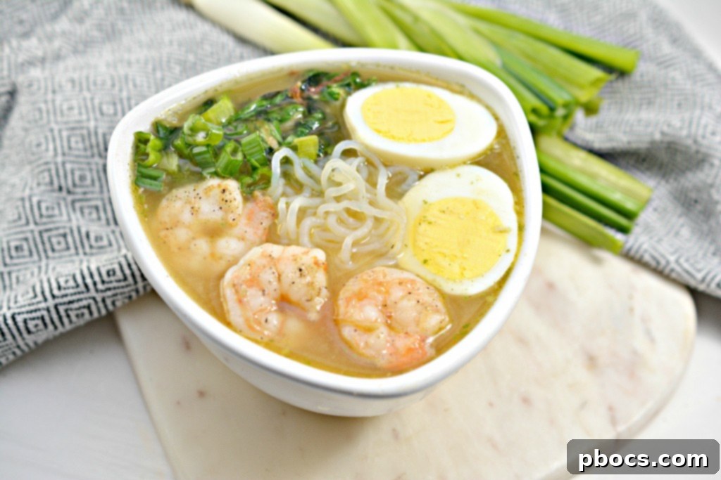 Close-up of creamy keto miso ramen soup with shrimp and garnishes