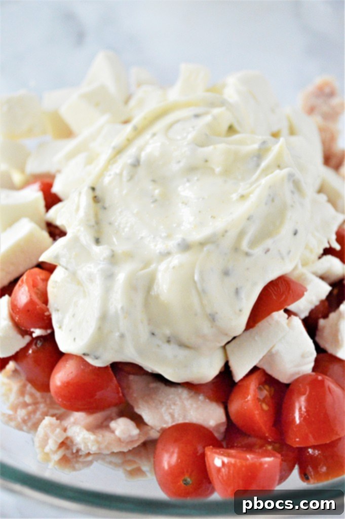 Keto Caprese Chicken Salad 11 Chicken, tomatoes, and mozzarella in a bowl