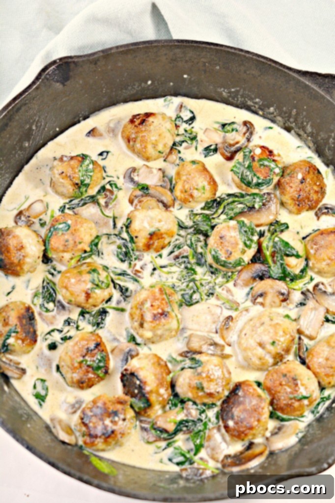 Flavor Packed Cajun Keto Chicken Meatballs 7 Close-up of Keto Cajun Chicken Meatballs cooking in a skillet with sauce and vegetables