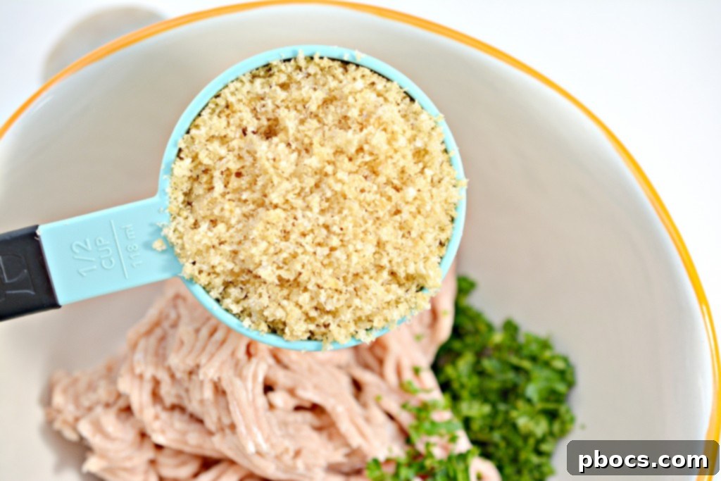 Flavor Packed Cajun Keto Chicken Meatballs 8 Hand mixing ingredients for Keto Cajun Chicken Meatballs