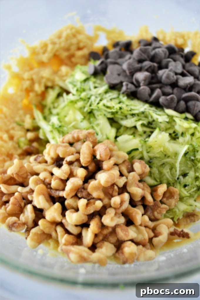 Zucchini bread batter with chocolate chips and walnuts in a loaf pan