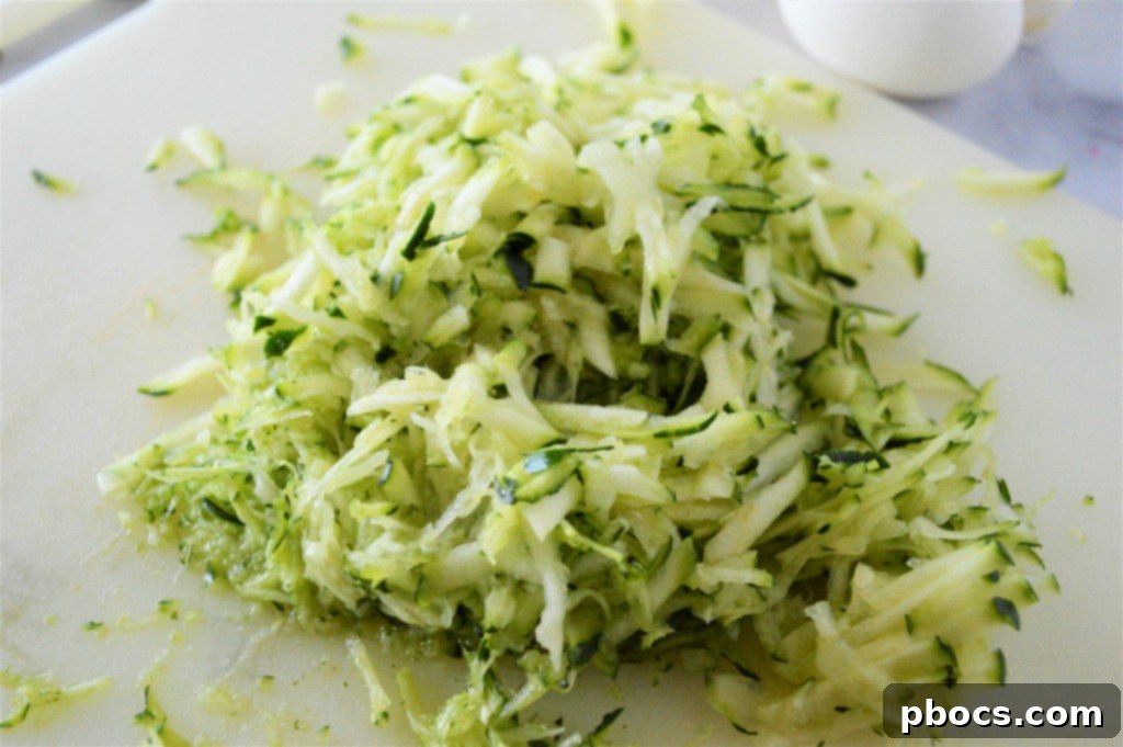 Grated zucchini being squeezed to remove moisture