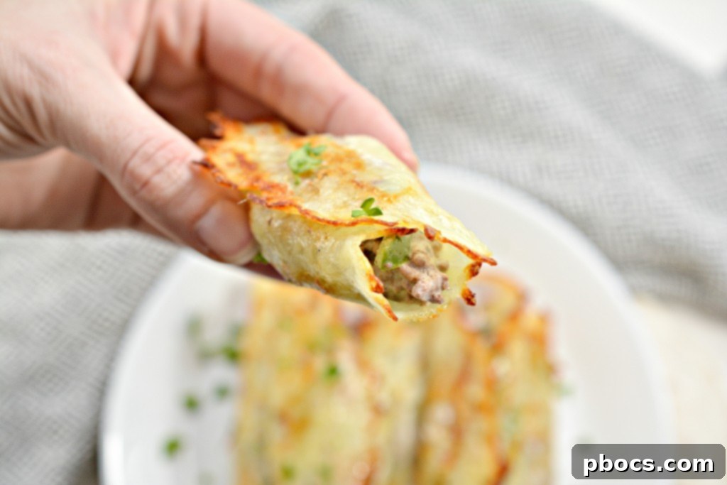 The process of filling a warm, pliable cheese wrap with cheesesteak mixture and gently rolling it