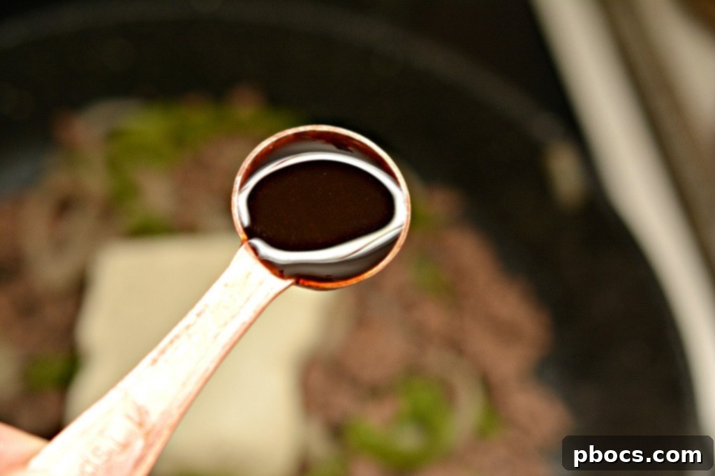 Adding softened cream cheese and Worcestershire sauce to the cooked beef and vegetable mixture