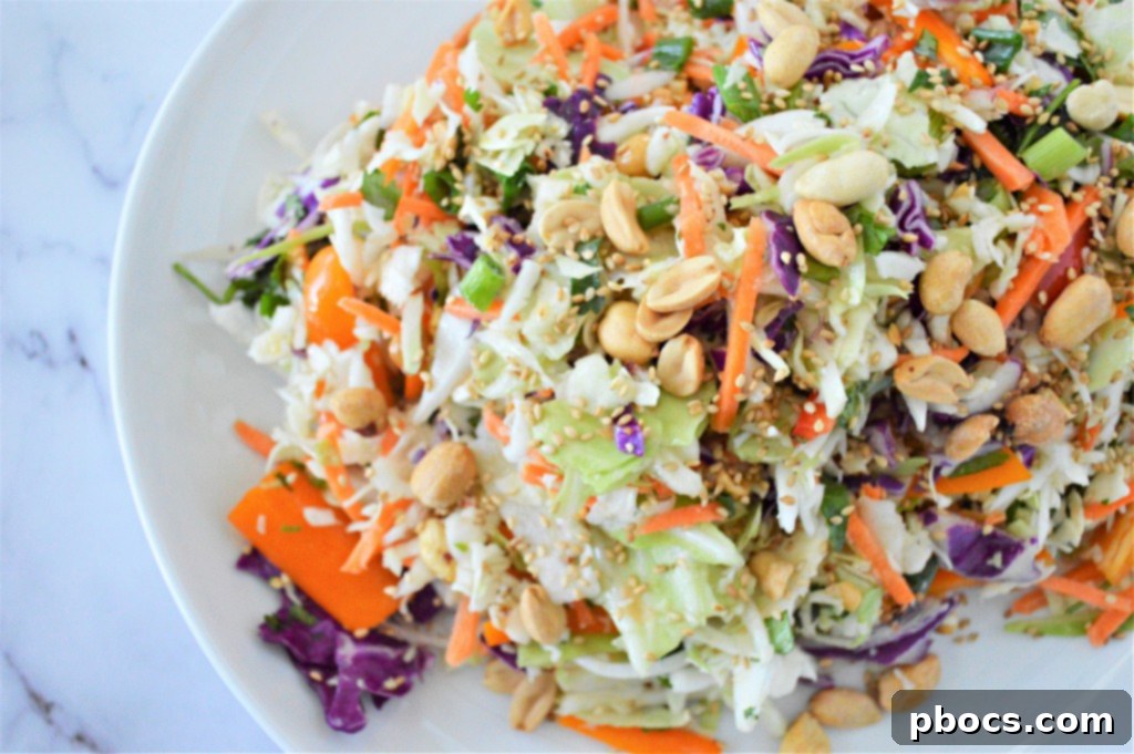 Zesty Keto Asian Slaw 5 Bowl of Low Carb Asian Slaw with dressing being poured over it