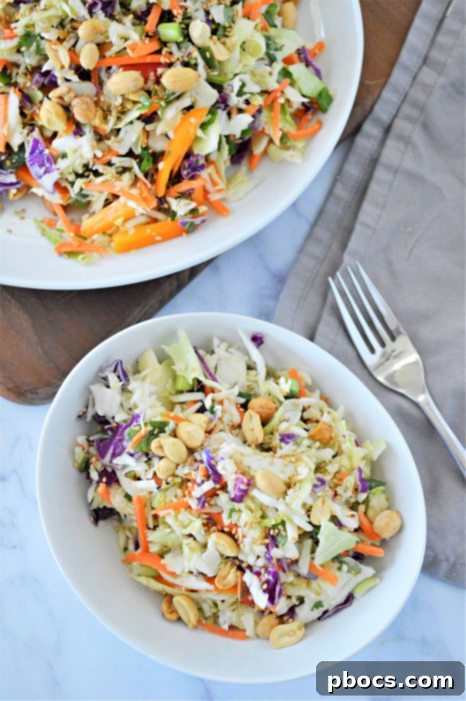 Zesty Keto Asian Slaw 6 Hand tossing Low Carb Asian Slaw with tongs in a large mixing bowl