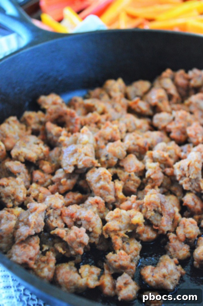 Stuffed Bell Pepper Nachos 9 Crumbled chorizo sausage cooking in a hot skillet, releasing its savory aromas