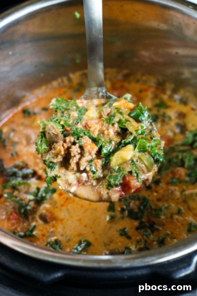 Stirring cream cheese, kale, and heavy cream into pizza soup