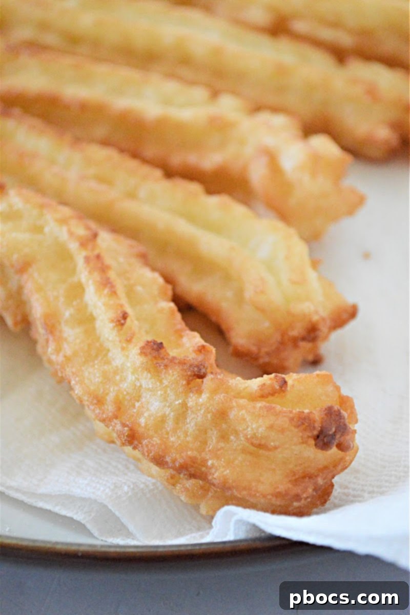 Piping churro dough directly into hot oil