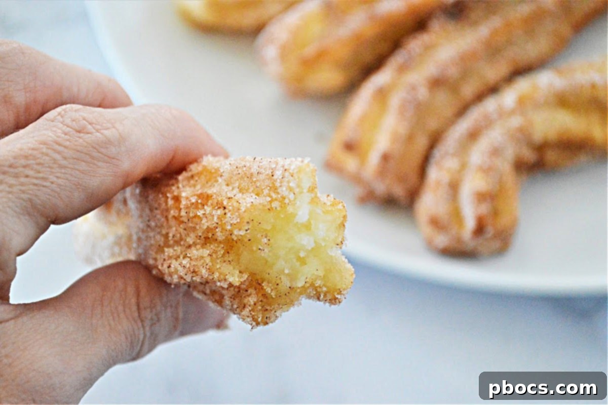 Close-up of freshly fried keto churro dough being piped