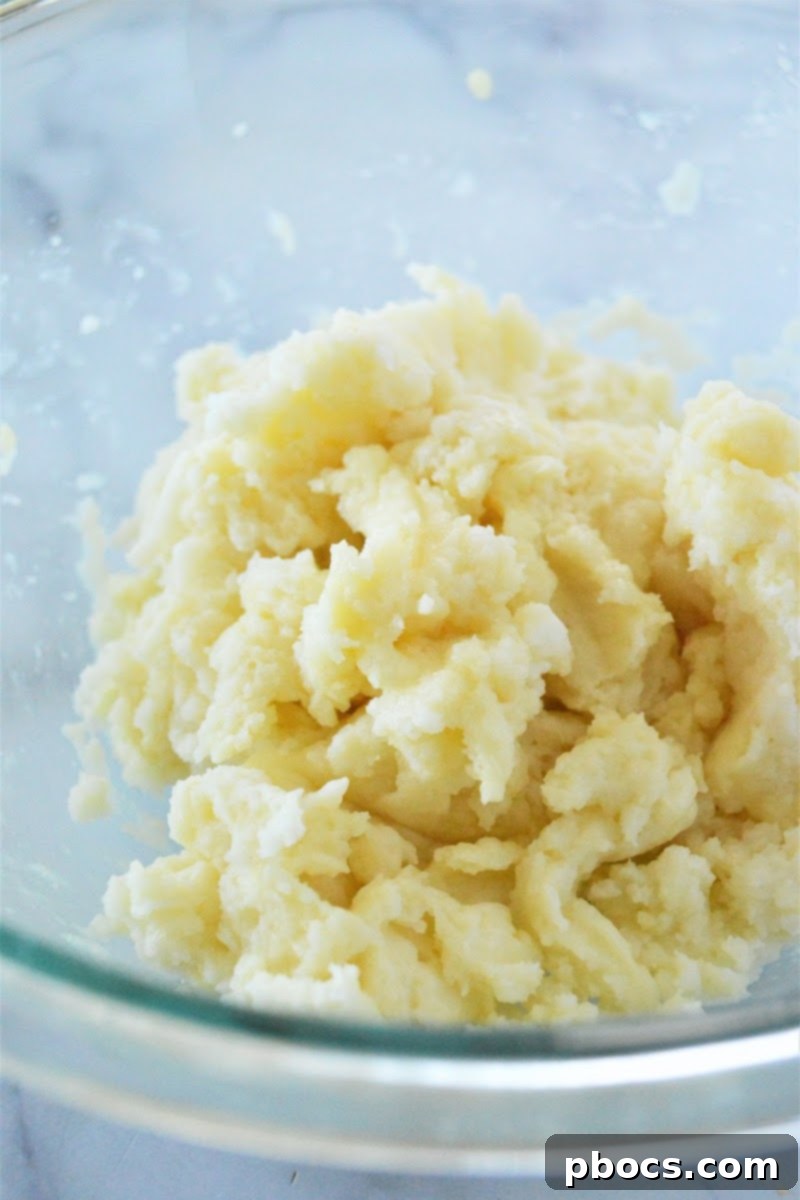 Churro dough being mixed with an egg