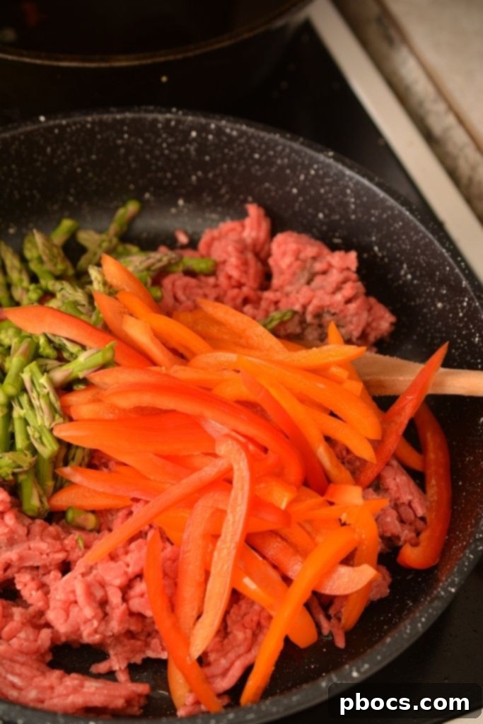 Ground Beef and veggies in a skillet browning