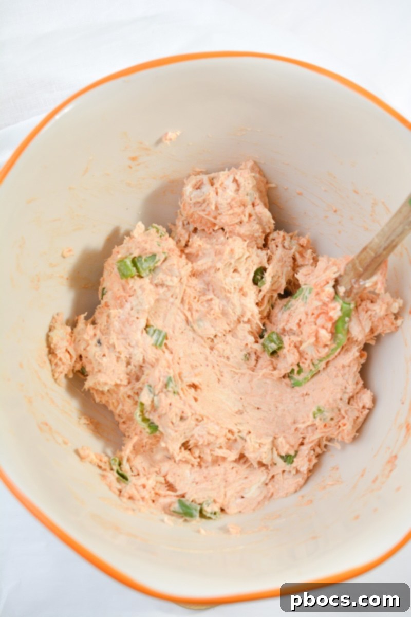 Cheesy Keto Chicken Enchilada Pinwheels 11 Mixing chicken, cream cheese, and enchilada sauce for filling