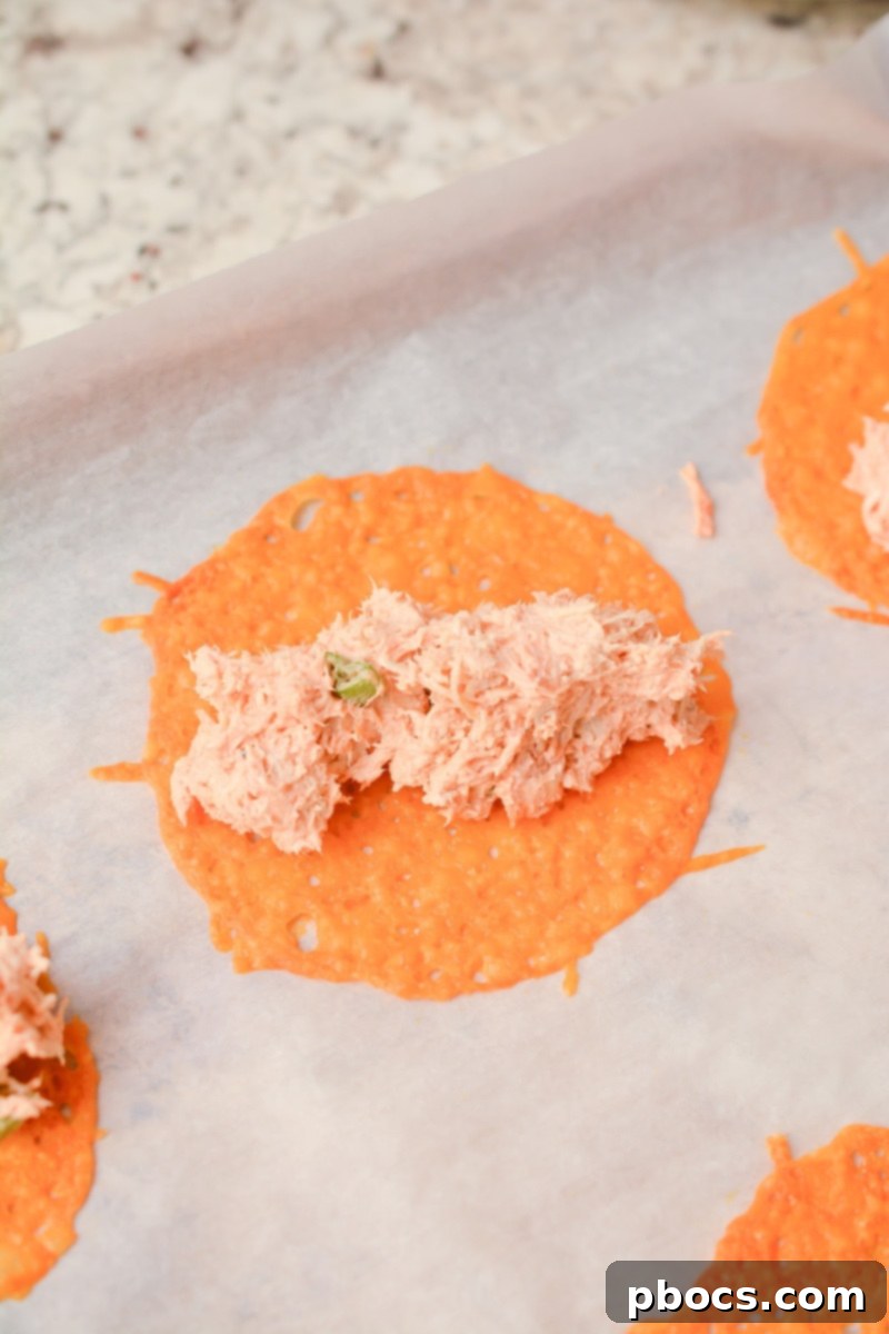 Cheesy Keto Chicken Enchilada Pinwheels 9 Arranging shredded cheddar cheese circles on parchment paper