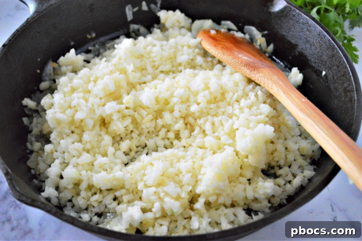 Zesty Cilantro Lime Cauliflower Rice with Creamy Avocado 11 Cooking cauliflower rice in a skillet